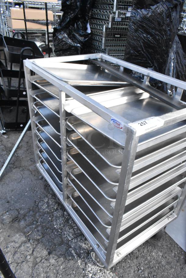 Metal commercial double pan transport rack with metal baking pans, Winholt brand. Features commercial casters, in used condition.
