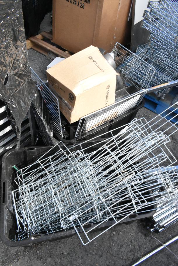 Lot of various metal pieces and wire racks in used condition. Includes Vitamix-labeled box and assorted metal parts.