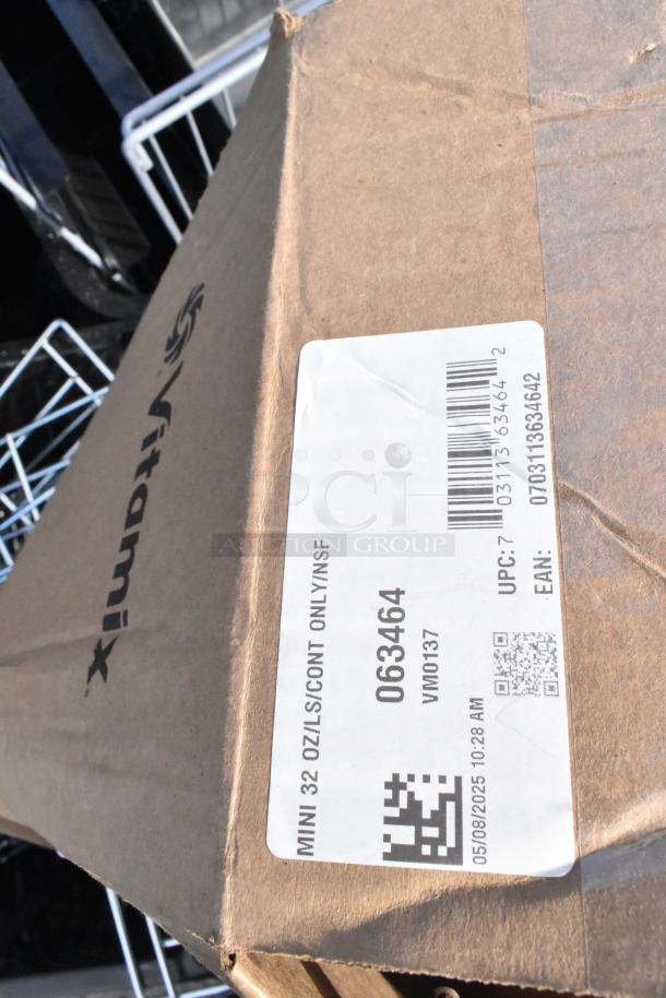 Cardboard box labeled "Vitamix," part of a mixed auction lot. Tag reads "MINI 32 OZ/LIS/CONT ONLY/NSF" with code 063464.