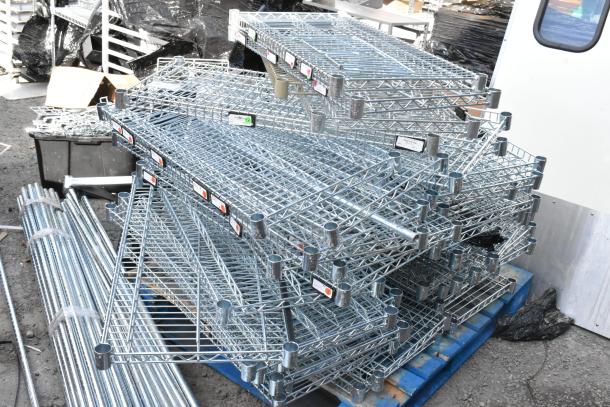 Chrome finish wire shelves and poles in bulk lot, stacked on a pallet, suitable for storage solutions.