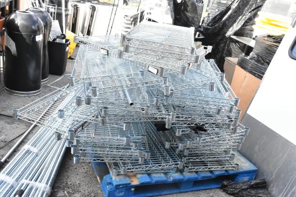 Chrome finish wire shelves and poles stacked on a blue pallet, assorted items included. Suitable for storage solutions.