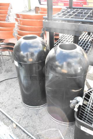 Two black metal trash can shells, cylindrical, with open tops and shiny surface. Good condition, auction for double bid.