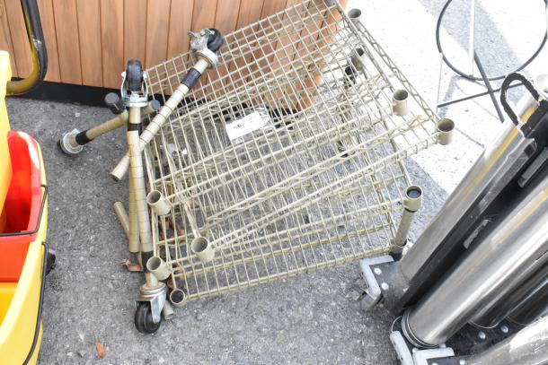 Tan finish 4-tier wire shelving unit with commercial casters. Disassembled state, includes poles and wheels.