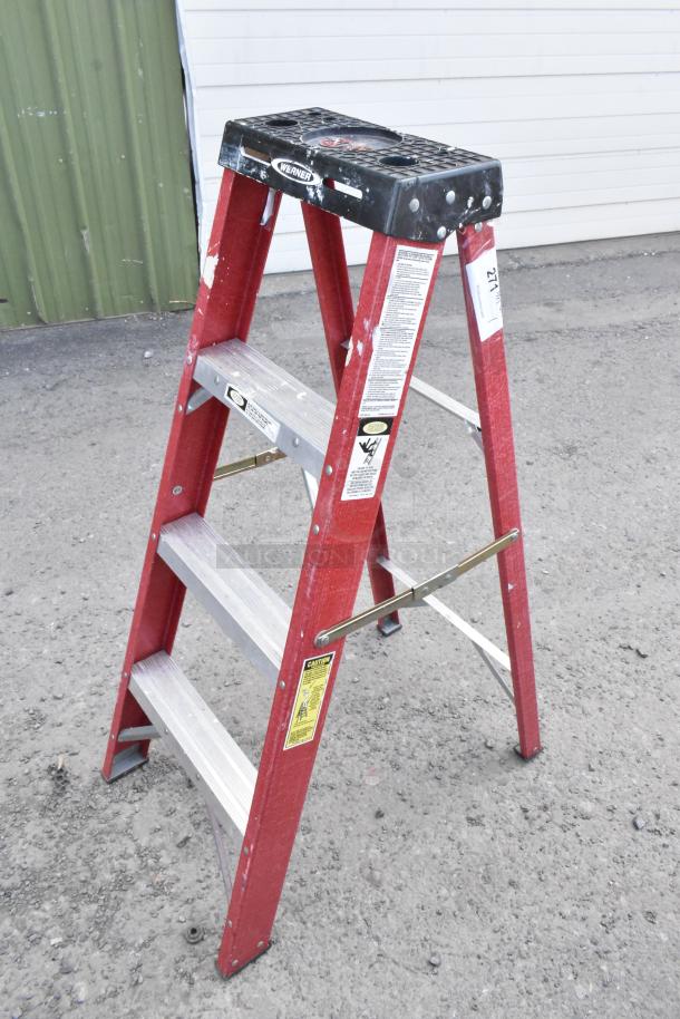 Werner A Frame Ladder, red, three-step, fiberglass construction, visible safety labels, minor paint marks, rugged condition.