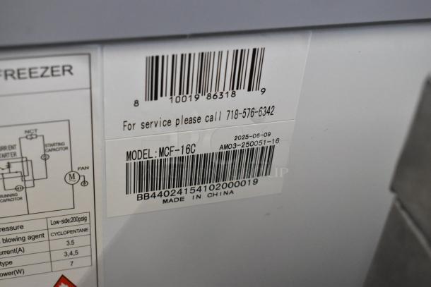 Label close-up on KoolMore MCF-16C Display Ice Cream Freezer. Shows model number, barcode, and service contact info.
