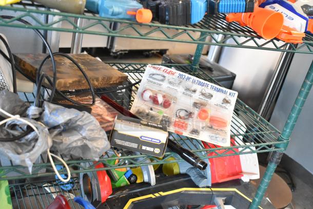 Two-tier shelf with various items including fishing lures, windchimes, and a Nintendo Switch controller holder. Items vary in condition.