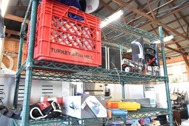 Two-tier shelf with various items including Sony speakers, Star Wars Darth Vader doll, toy truck, and sports jerseys.