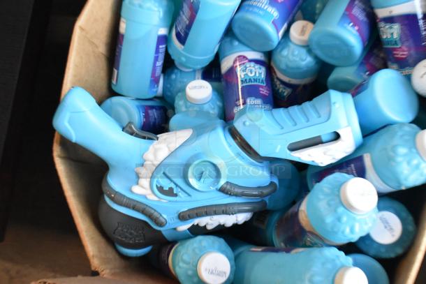 Lot of blue Fom Concentrate bottles and a bubble gun, all in used condition, in a large cardboard box.