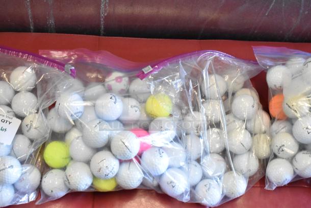 Lot of various golf balls including TaylorMade and Callaway, in ziplock bags, mixed colors and conditions.