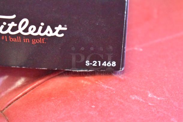 Lot of golf balls including brands like TaylorMade and Callaway. Titleist packaging with "#1 ball in golf" and code S-21468 visible.