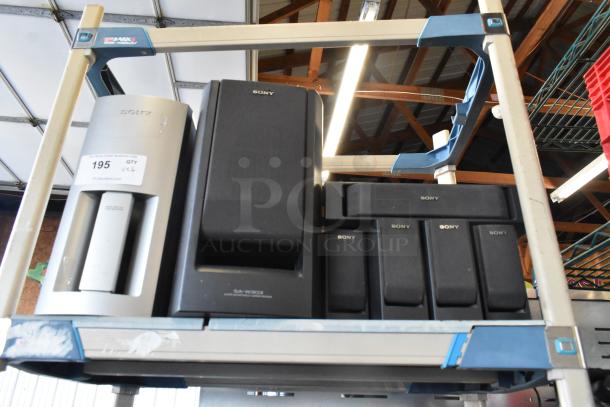 Sony speaker set, including various models, displayed on shelves. Features include black and silver finishes. Auction tag visible.