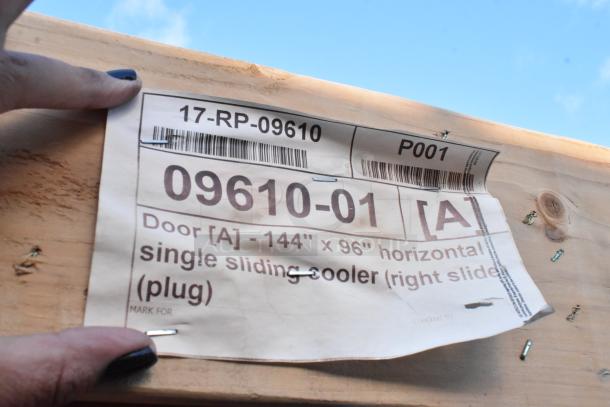 Brand new 17-RP-09610 walk-in door, 144"x96", labeled scratch and dent. Tag shows model and size details.