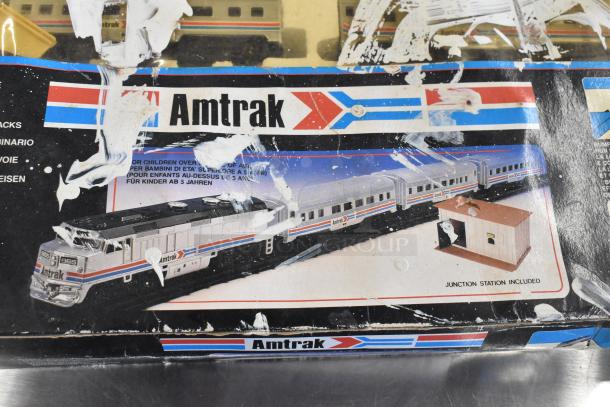 Amtrak 6042 Toy Train in original packaging with visible wear, featuring locomotive and carriages. Includes junction station.