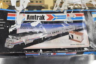 Amtrak 6042 Toy Train in original packaging with visible wear, featuring locomotive and carriages. Includes junction station.