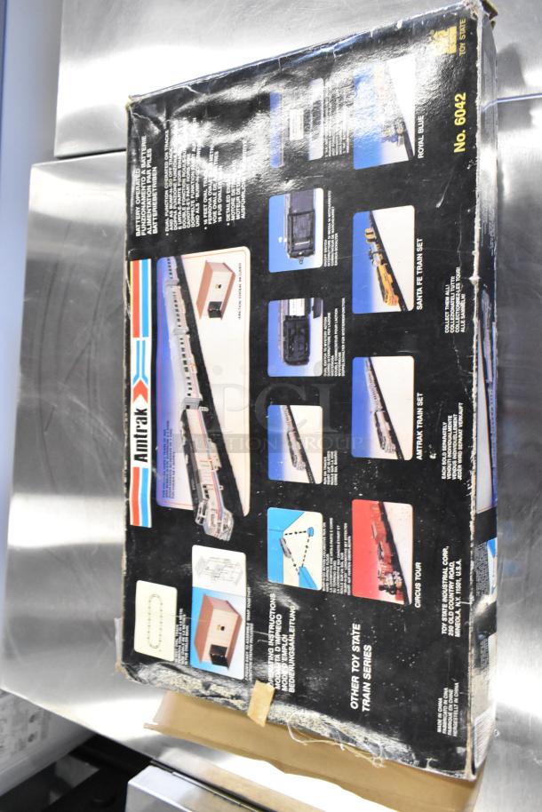 Box of Amtrak 6042 Toy Train Set, vintage packaging with wear. Features train images and assembly instructions.