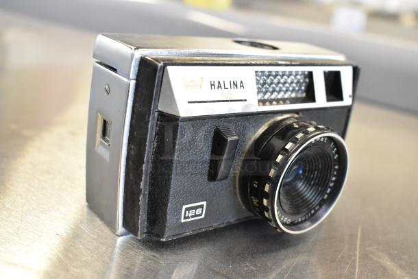 Halina 1:5.6 film camera, model 300, vintage design, minor wear. Includes Honeywell Tilt-a-mite gauge for auction.