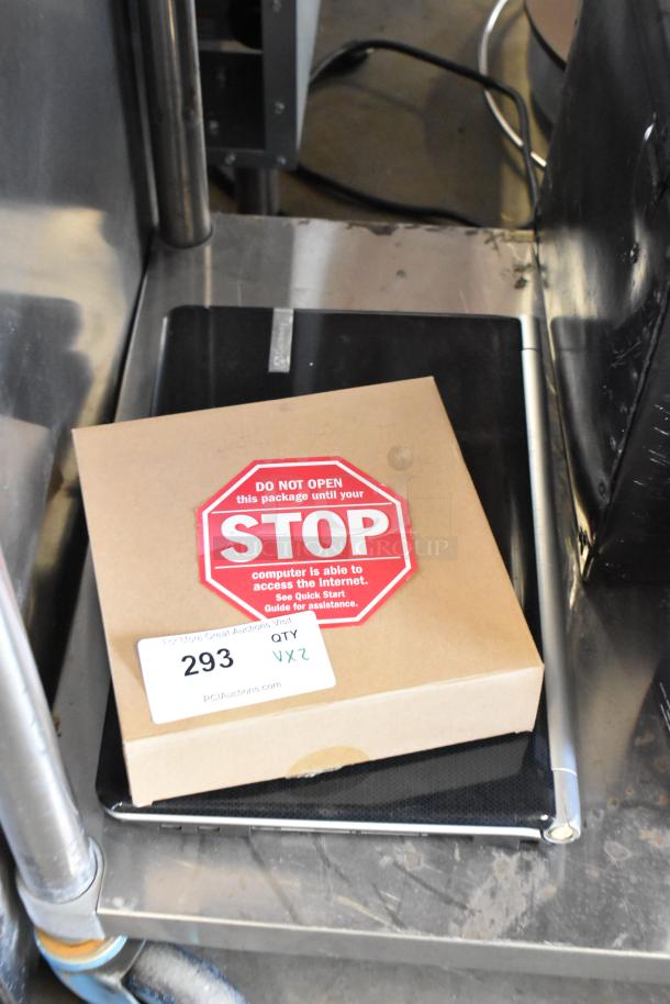 Netgear router in unopened box with warning label, placed on Gateway KAYF0 laptop, auction lot 293.