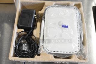 Netgear router in packaging with power adapter; good condition. Includes router model marking and packaging details.