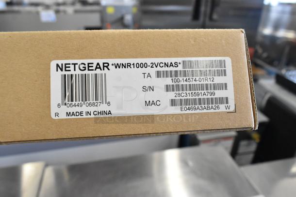 Netgear WNR1000-2VCNAS router new in box. Label shows barcodes, model number, S/N 28C315591A799, MAC E0469A3ABA26. Made in China.