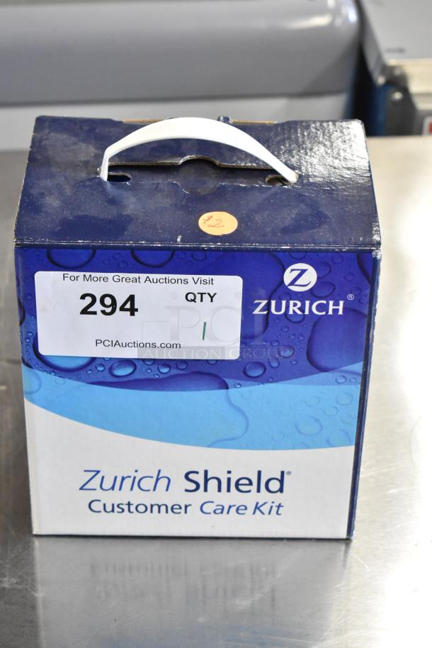 Zurich Shield Customer Care Kit in box, new condition. Features brand logo and auction label with item number 294.