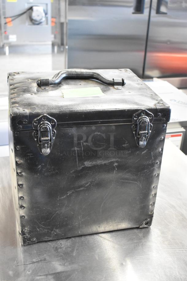 Black hard case with metal rivets and latches, contains Humble Film Library films, moderate wear, vintage storage item.