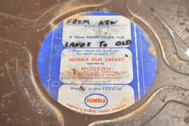 Rustic hard case with a "Humble Film Library" label, marked "16mm Sound Color Film, Lands to Old," indicating contents.