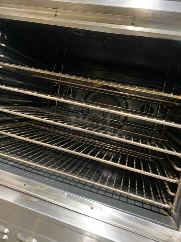 Blodgett commercial stainless steel natural gas double convection oven with wired racks, on legs, visible internal cavity.