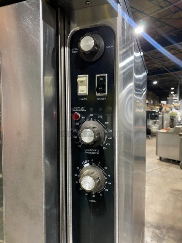 Blodgett stainless steel double-stacked convection oven, natural gas, features wired racks and control panel, on legs.