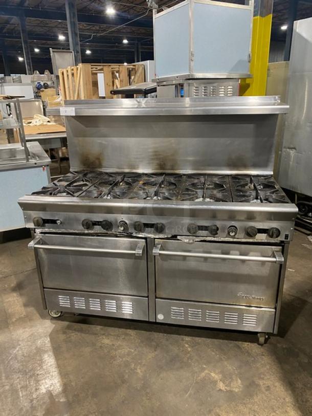 U.S. Range stainless steel 10-burner gas range with dual ovens, backsplash, overhead salamander shelf, and wired racks on casters.