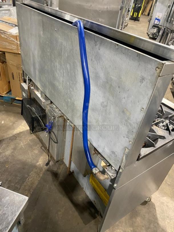 U.S. Range commercial stainless steel 10-burner range with double oven, backsplash, overhead salamander shelf, and wired racks. On casters.