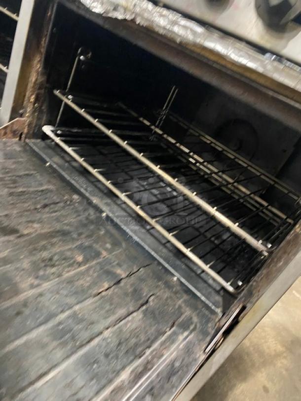 U.S. Range stainless steel natural gas 10 burner range with double oven, overhead salamander shelf, and wired oven racks.