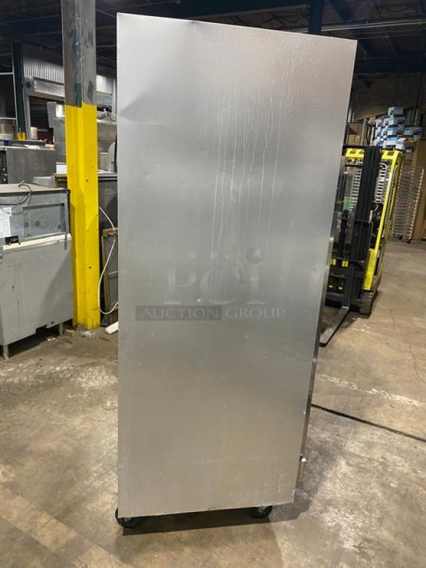 Traulsen G31010 commercial stainless steel triple door reach-in freezer, with poly-coated wired racks, on casters.