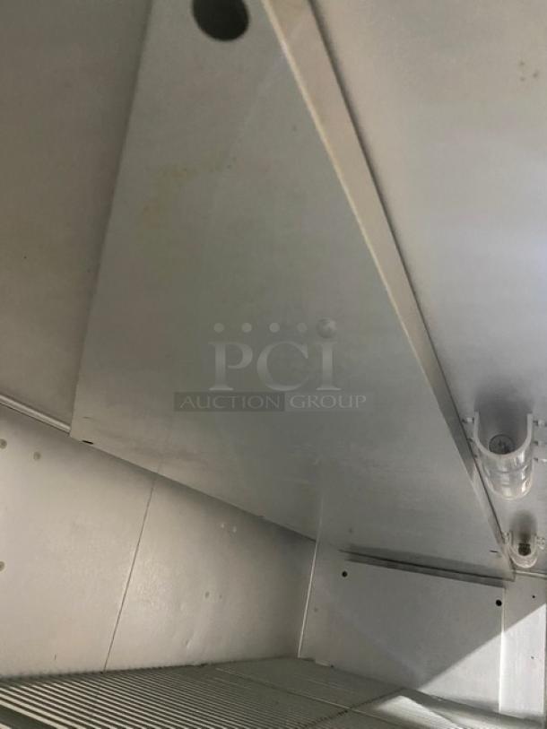 Traulsen G31010 commercial stainless steel triple door reach-in freezer interior, with poly-coated wire racks, on casters.