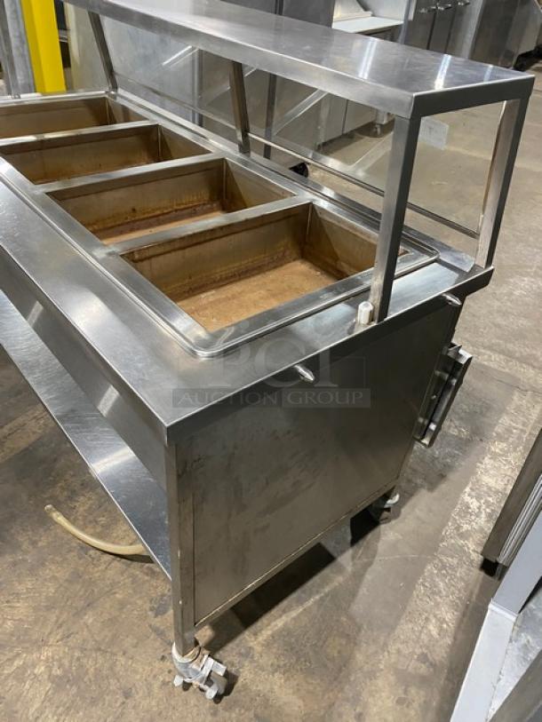 Atlas Metal WIH-D&M-4 stainless steel 4-well steam table with sneeze guard, electric 208V, on casters, serial 14063336A.