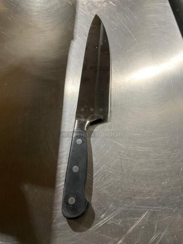 Commercial stainless steel chef knife with black grip handle, excellent condition. Suitable for professional kitchens.