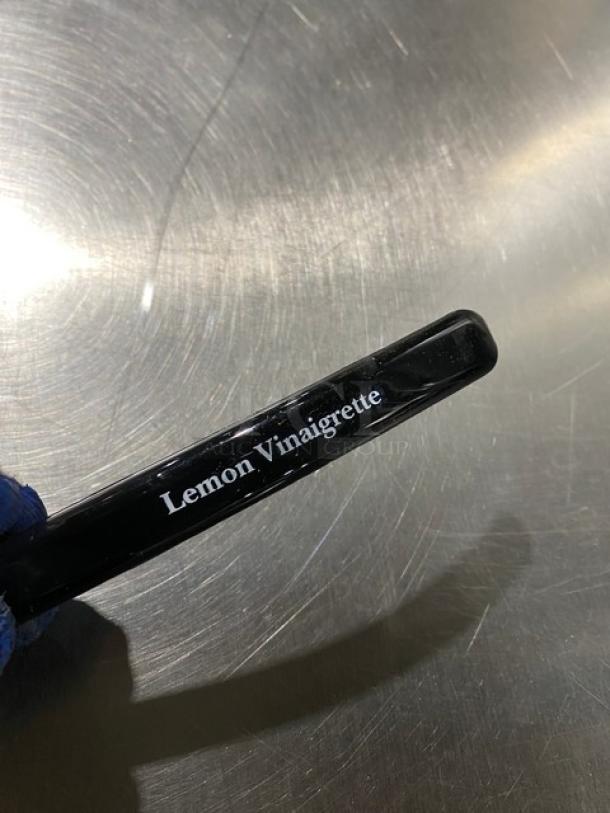 Brand new Carlisle Lemon Vinaigrette Style Ladle, black, 9.5", Model 02955979, with item label visible.