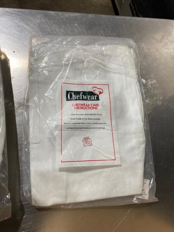 Chefwear commercial white waist/bistro apron model CW1611, with pockets, new in packaging. Care instructions visible.