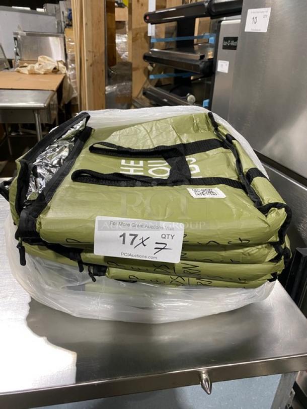 Green insulated meal delivery bag, new condition, stacked with labels indicating auction lot "QTY 7," on metal surface.