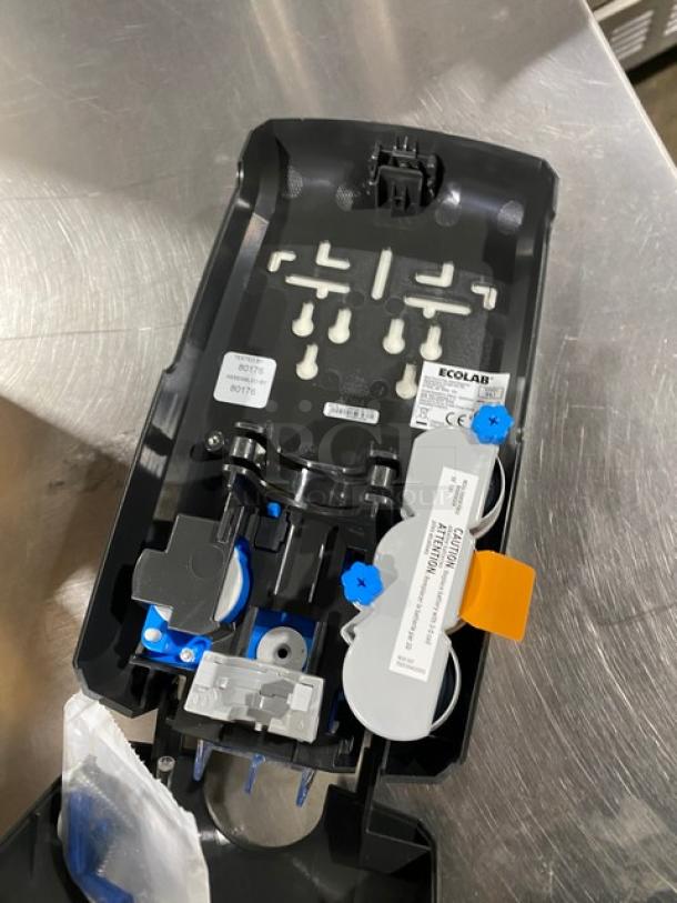 Ecolab Nexa Series black touch-free hand hygiene dispenser, new condition, open showing internal components and labels.