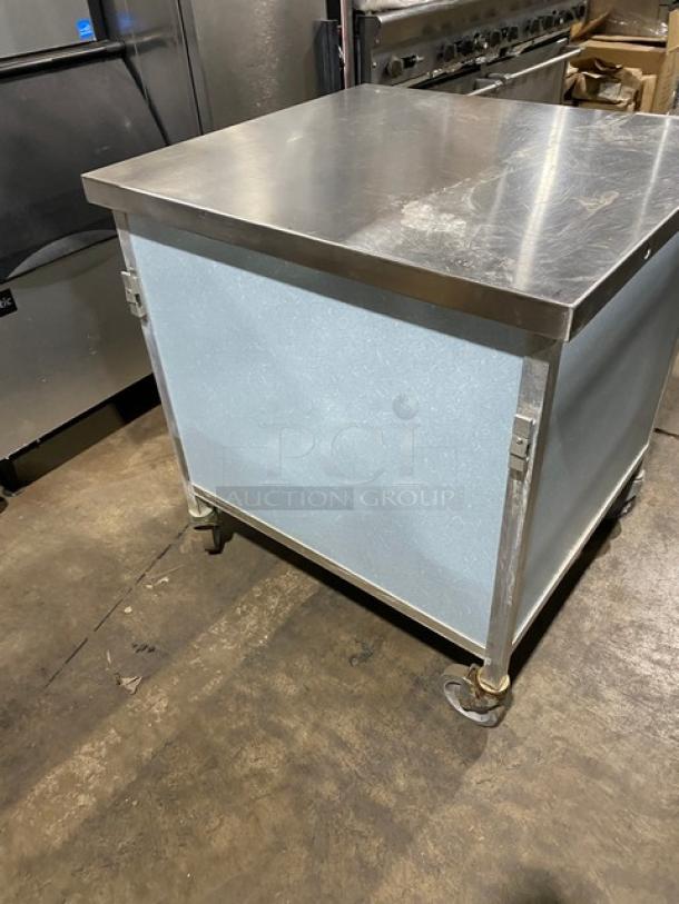 Commercial stainless steel rolling kitchen utility table on casters, features durable top, sturdy condition, easy mobility.