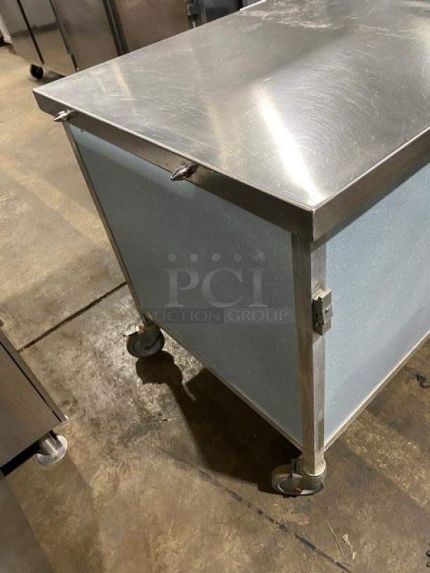 Commercial stainless steel rolling kitchen utility table on casters, durable condition, ideal for professional kitchens.