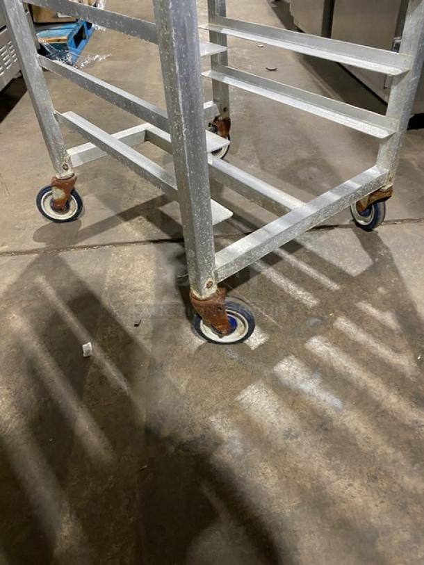 Alexander Industries commercial stainless steel steam rack on casters, showing signs of use, ideal for kitchen storage and mobility.