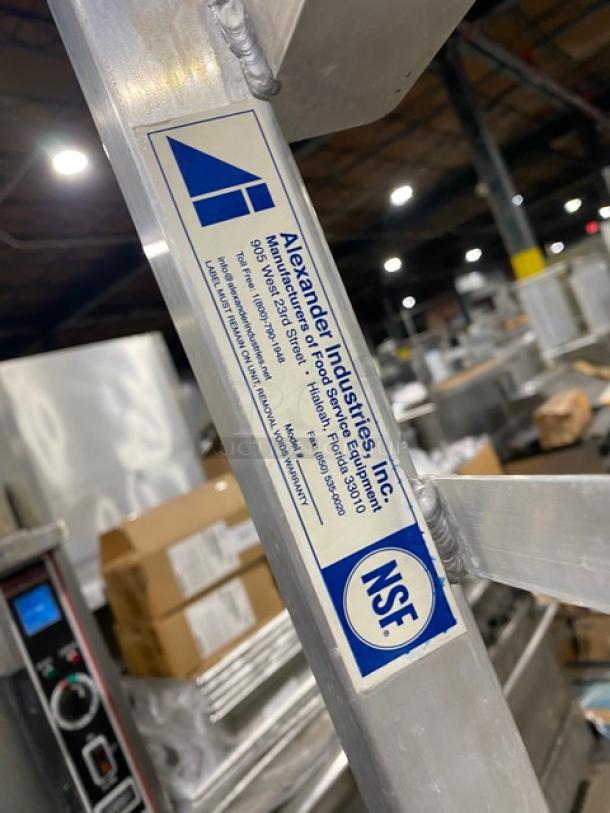 Alexander Industries commercial stainless steel steam rack, on casters, with NSF certification label.