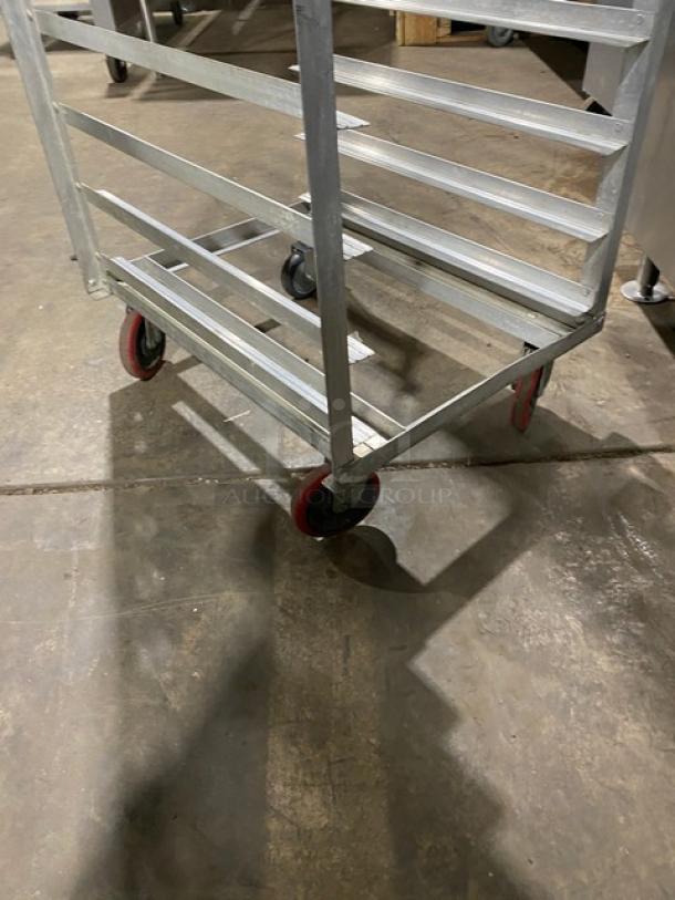 Commercial stainless steel hot food steam rack with multiple shelves on red casters. Durable condition. Ideal for kitchens.