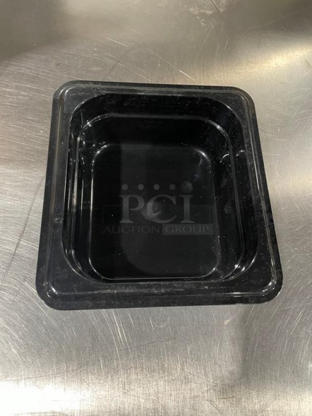 Carlisle 3068303 black 1/6-size food pan, 2.5" deep, in new condition on stainless steel surface.