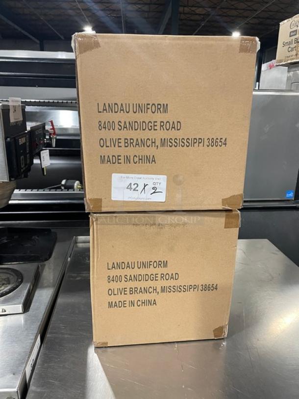 Boxes of Landau Uniforms commercial white non-woven 9" round chef hats. New condition, marked "Made in China."