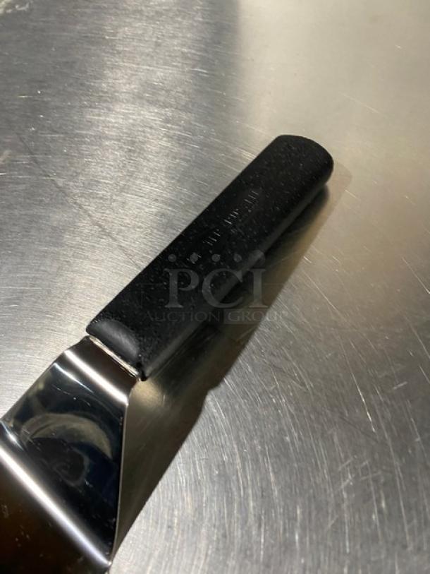 Dexter Russell Sani-Safe stainless steel hamburger turner, model S286-4, with a black grip handle, new condition.