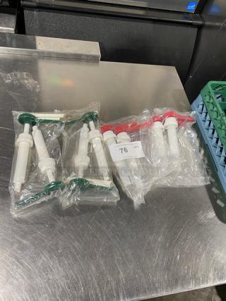 New commercial condiment dispenser pumps, bagged, featuring green and red handles, unused. Quantity tag shows "76 QTY".