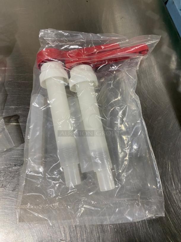 New commercial condiment dispenser pump, sealed in plastic, features red handles and white pump tubes; ideal for food service.