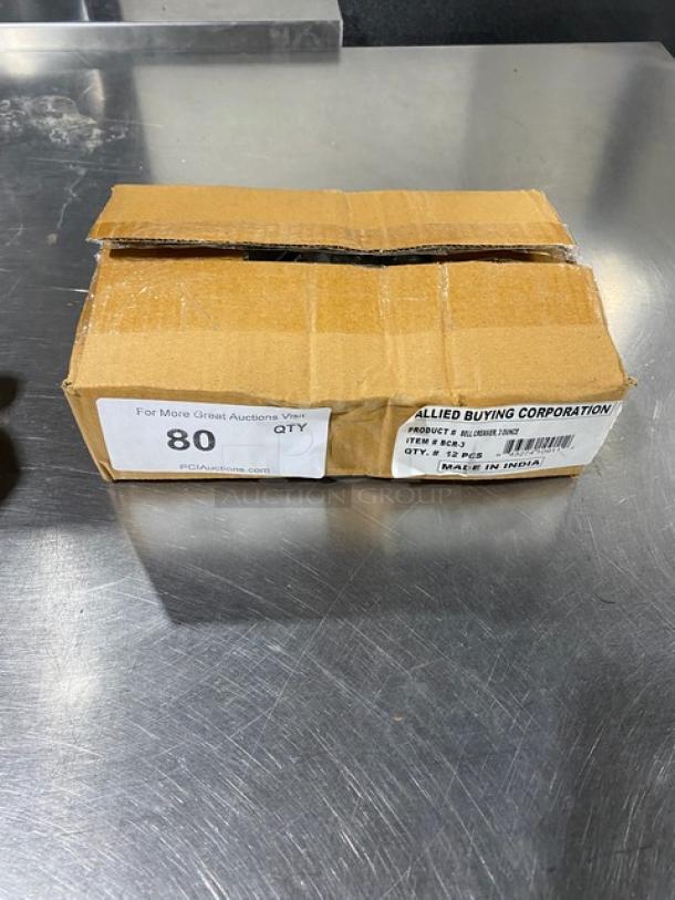 Cardboard box labeled with "ABC Commercial Stainless Steel 3 Oz Bell Creamer, Model BCR-3, Made in India," on a metal surface.